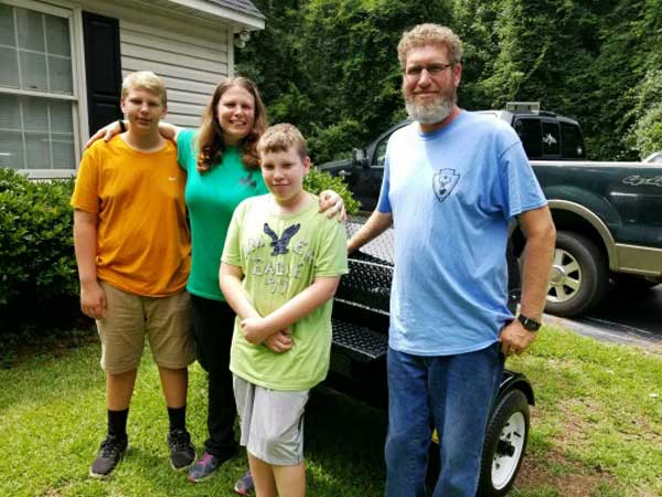 David C., with family picking up their Carolina Pig Cooker.